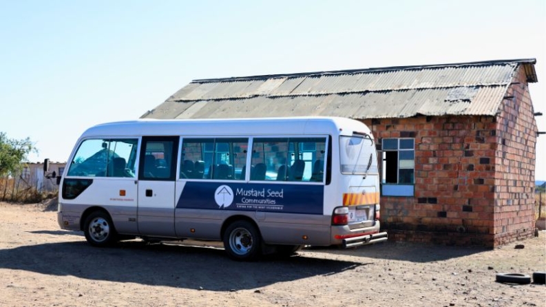 A bus with Mustard Seed's logo waits outside the Little Angel's School.